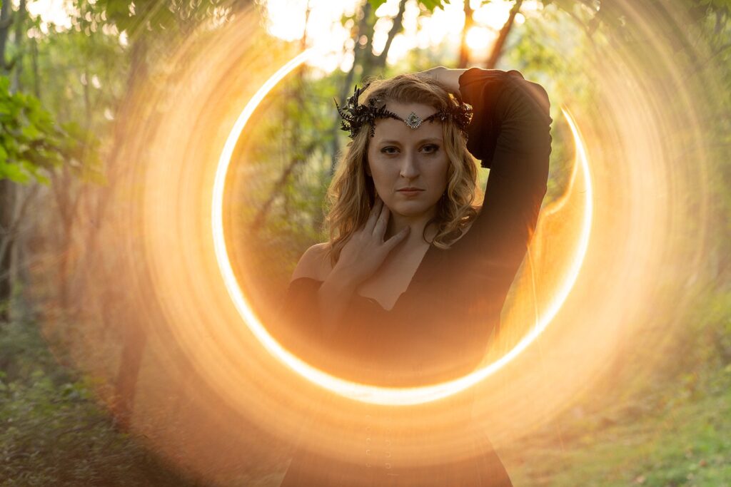 ring of fire around a woman wearing a crown and black dress, looking sultry and fierce.