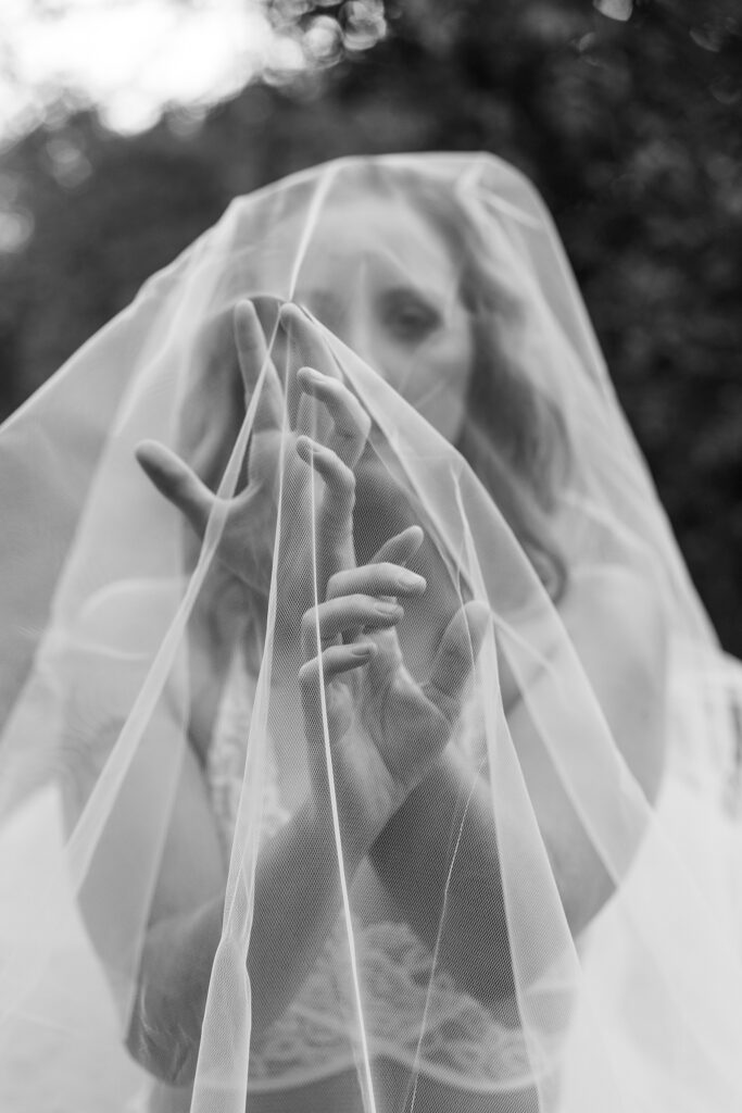 Detail shot of hands behind a veil