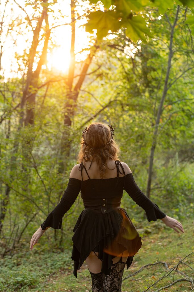 Woman walking away with short dress, and thigh high stockings in a golden hour shoot in the woods.